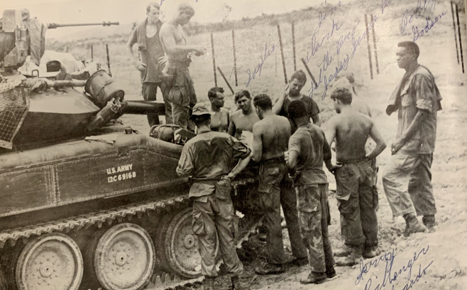 H Troopers gathered beside an armored vehicle at base camp