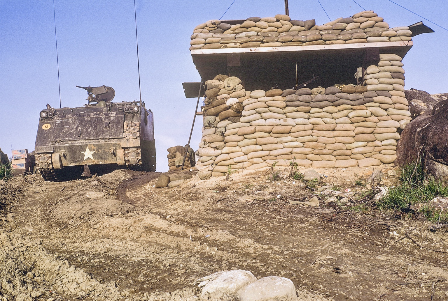 An armored vehicle beside a sandbagged perimeter bunker at LZ Bayonet