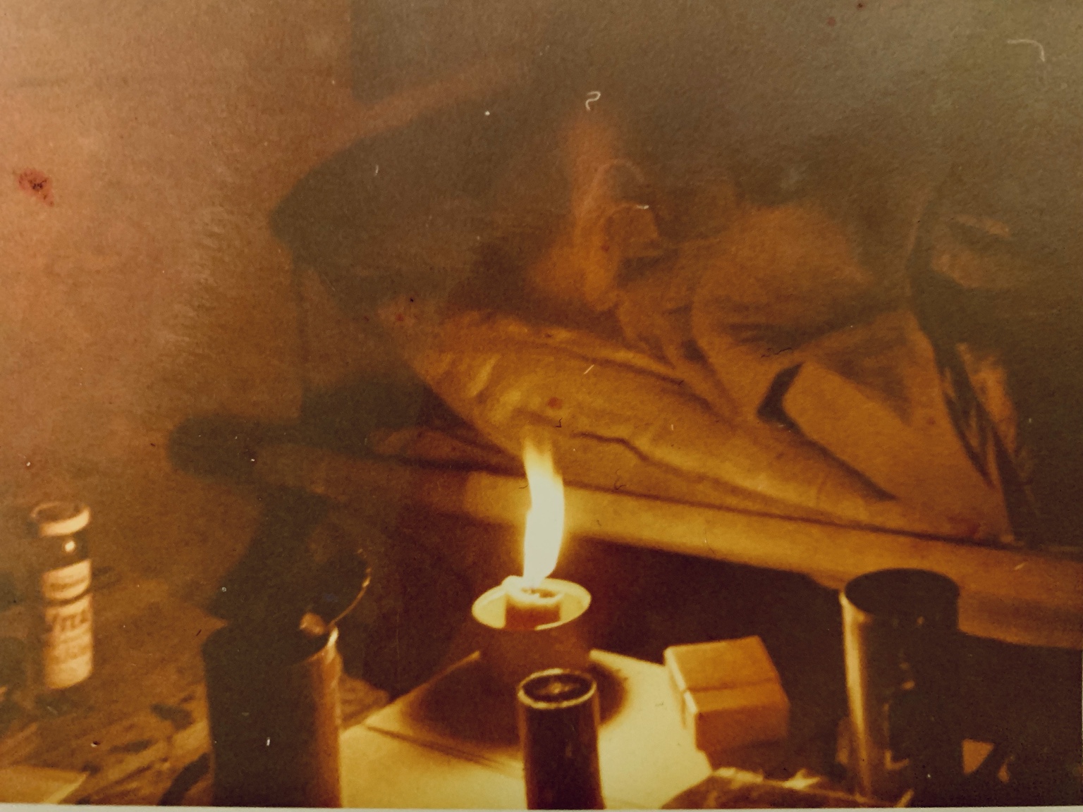 A trooper resting beside a small flame inside dim quarters