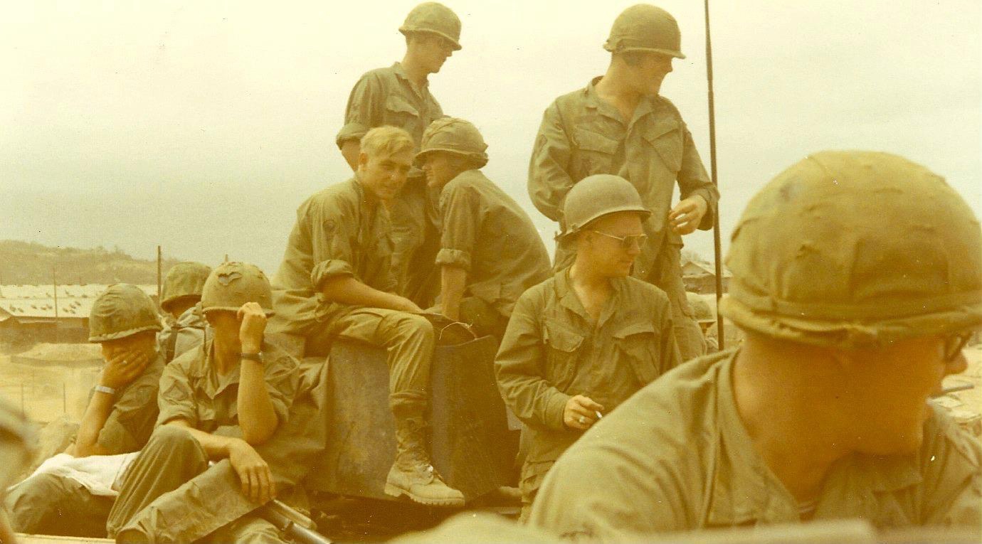 Helmeted troopers aboard a track.