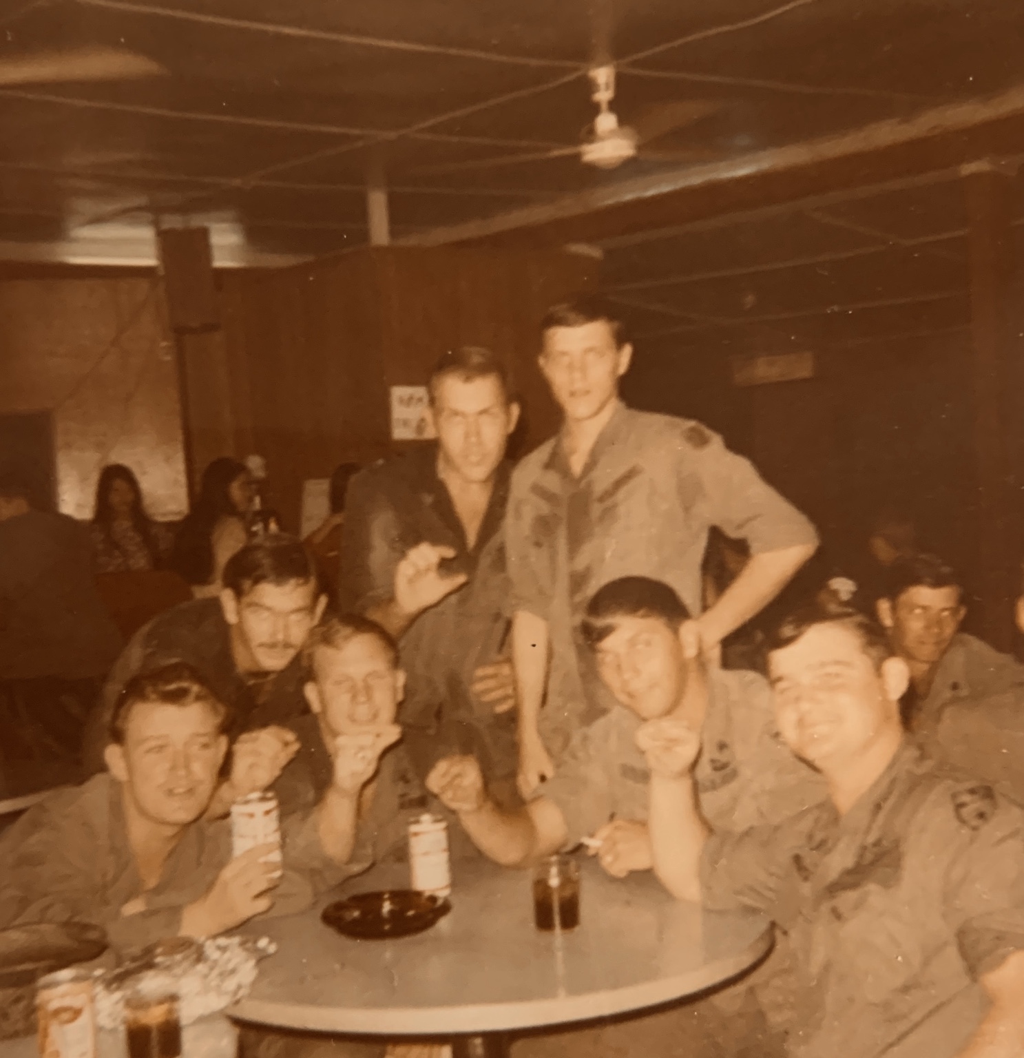 A group of troopers gathered closely around a table during an off-duty moment.