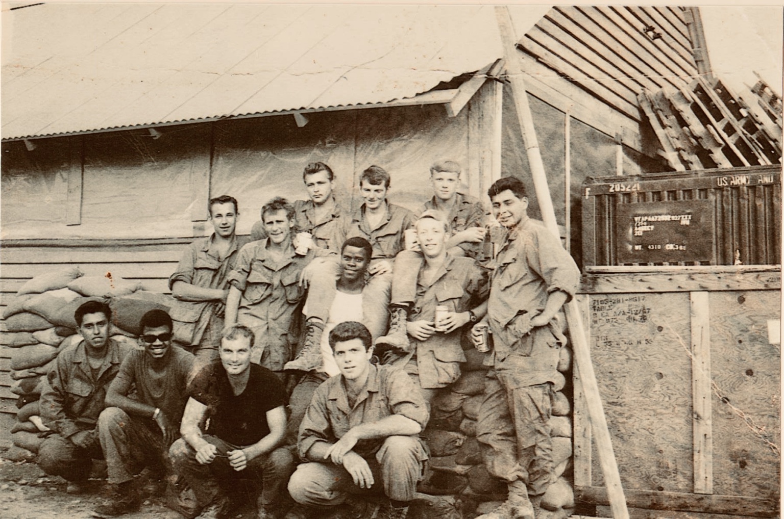 A group of troopers beside sandbagged quarters.